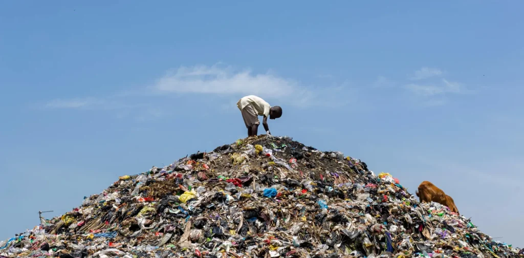 seorang pria di atas tumpukan sampah