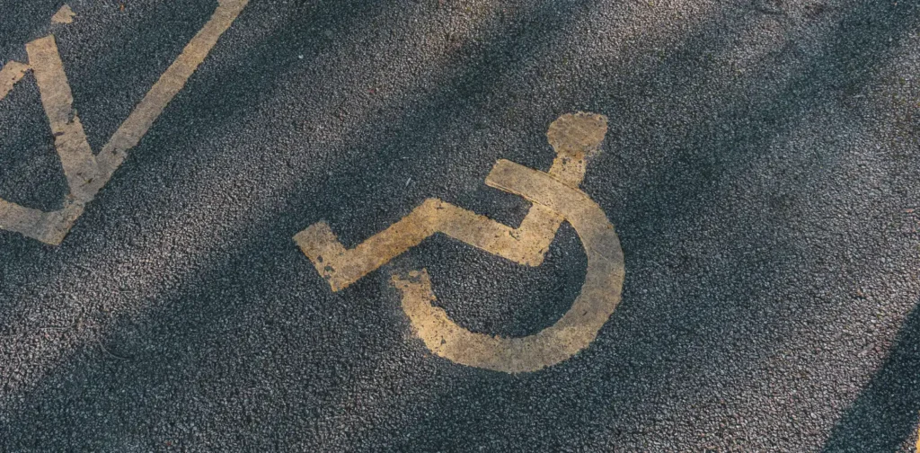 simbol orang dengan disabilitas dengan kursi roda di atas aspal jalan