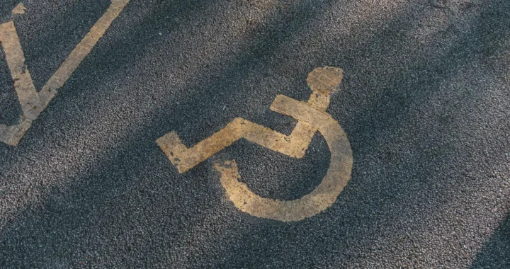 simbol orang dengan disabilitas dengan kursi roda di atas aspal jalan