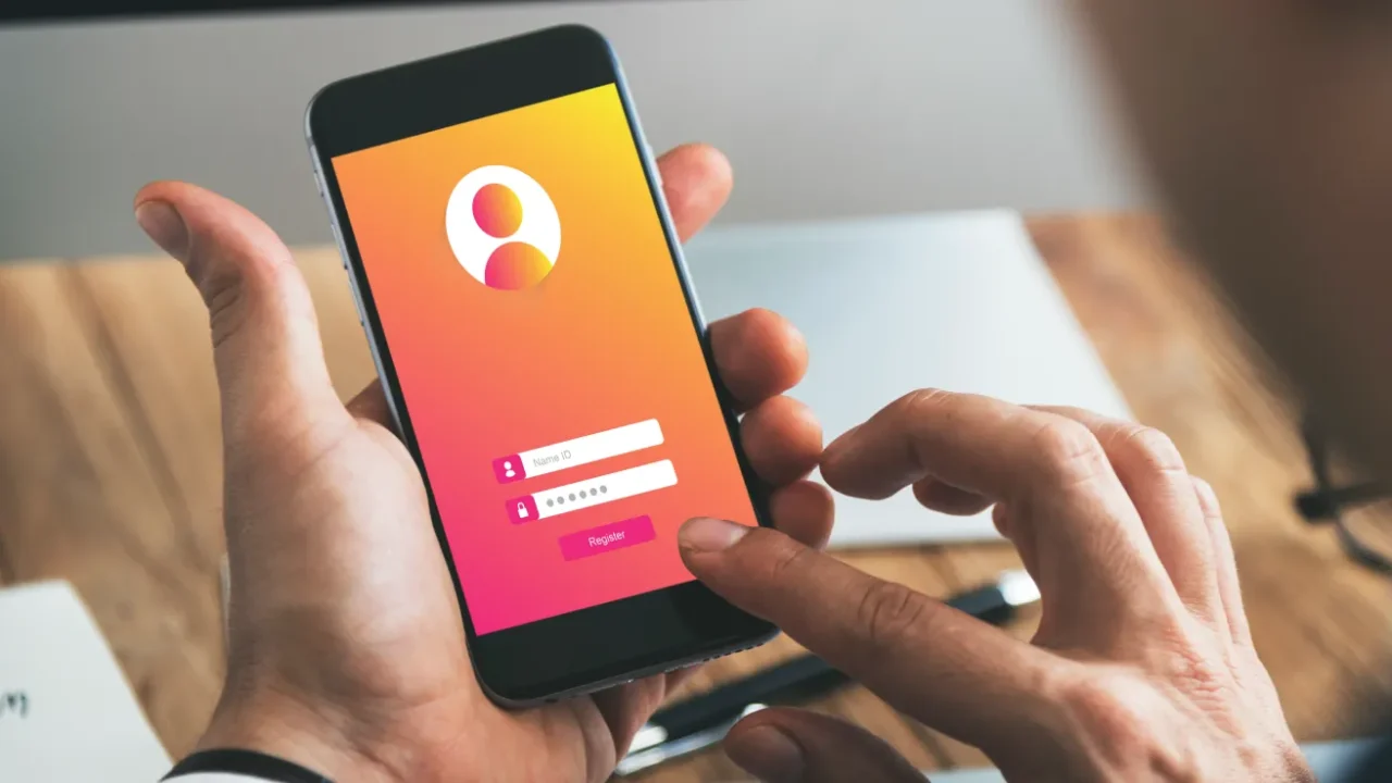 foto tangan memegang smartphone dengan layar membuka halaman untuk memasukkan informasi akun password