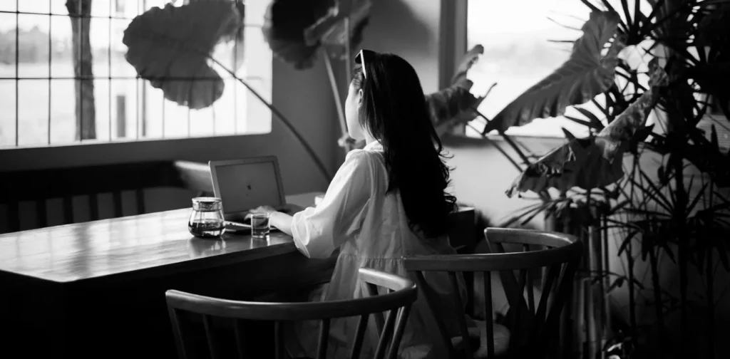 perempuan sedang bekerja dengan laptop di meja