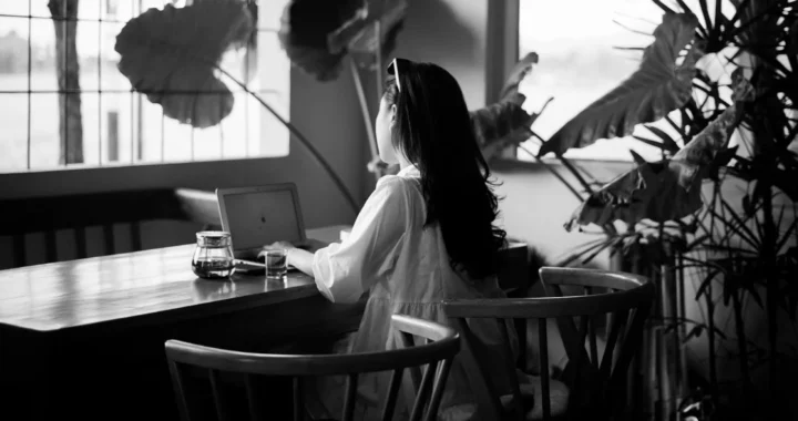 perempuan sedang bekerja dengan laptop di meja