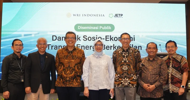 7 orang berfoto bersama di hadapan laya presentasi