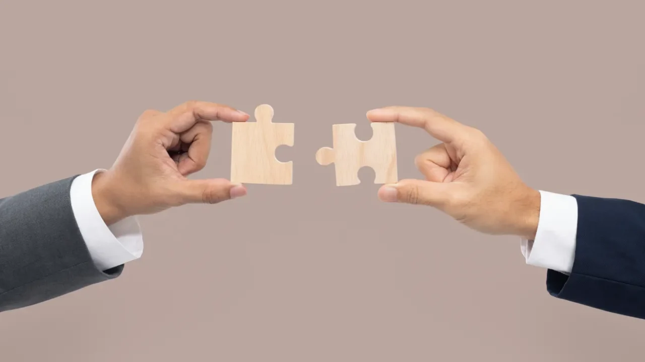 dua tangan mendekatkan puzzle