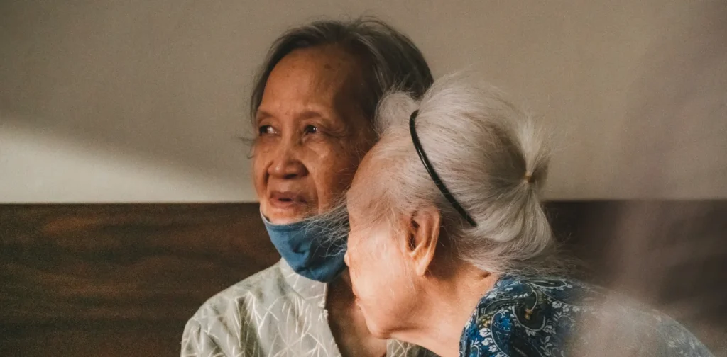 dua lansia dengan satu berkemeja coklat abu-abu dan yang lain berkemeja biru bermotif