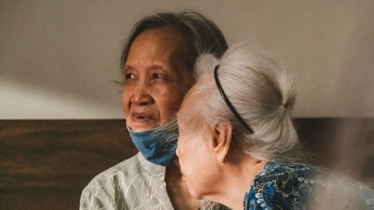 dua lansia dengan satu berkemeja coklat abu-abu dan yang lain berkemeja biru bermotif