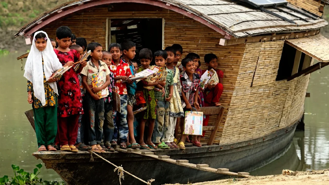 sekelompok anak-anak dengan peralatan belajar di atas perahu
