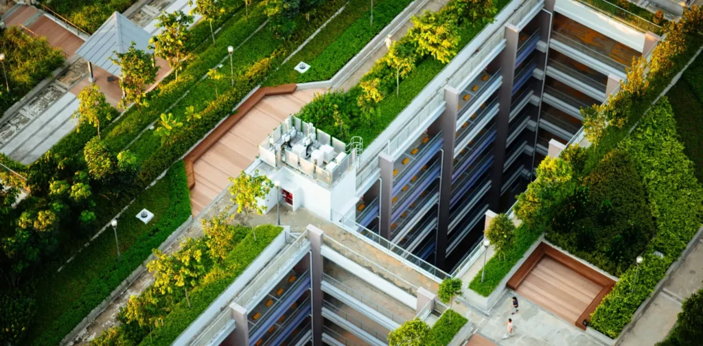gedung tinggi dengan pepohonan dan rumput hijau di sekelilingnya