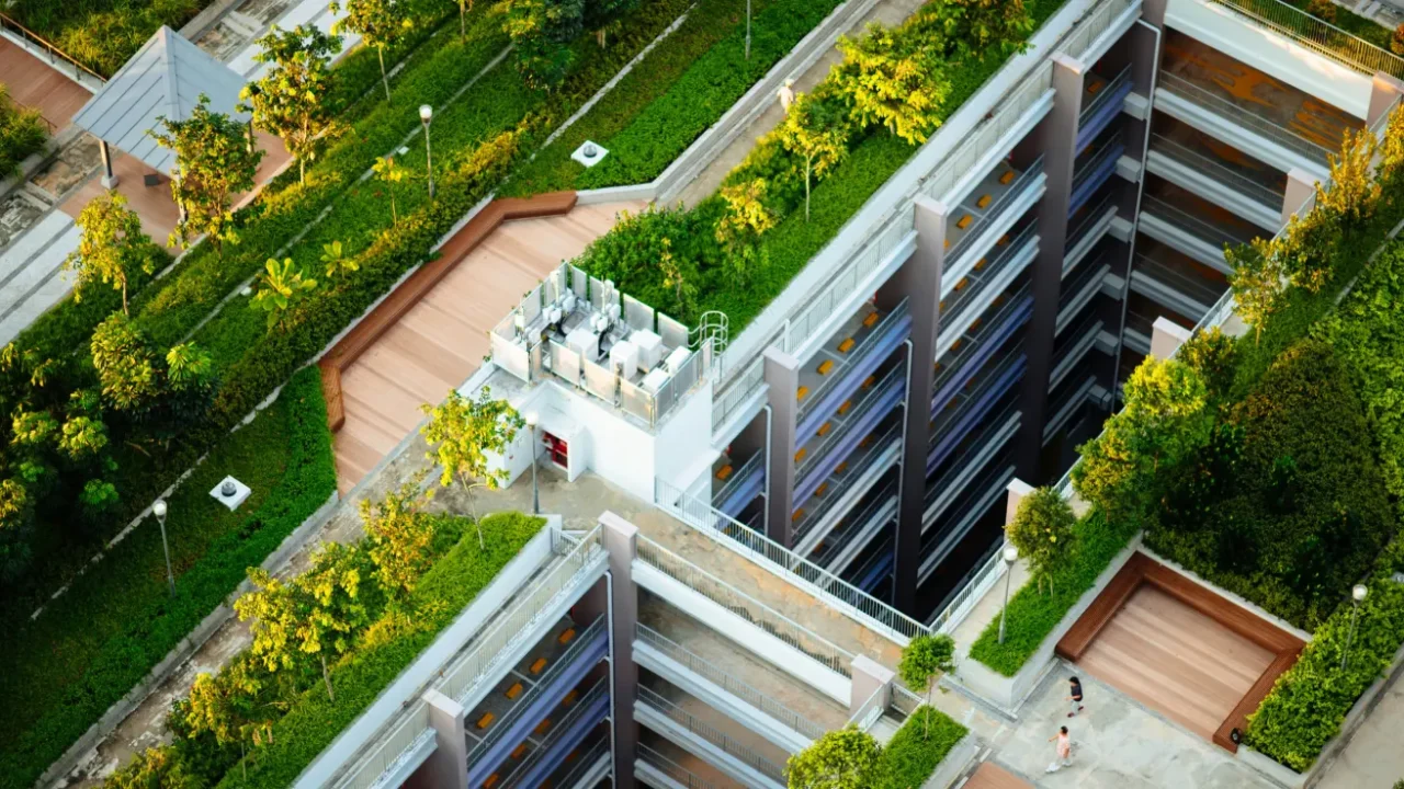 gedung tinggi dengan pepohonan dan rumput hijau di sekelilingnya