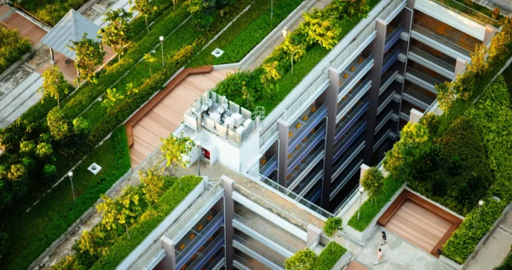 gedung tinggi dengan pepohonan dan rumput hijau di sekelilingnya