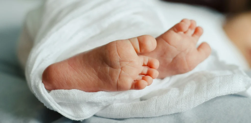 sepasang kaki bayi berbalut kain putih
