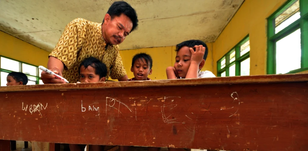 seorang guru mengajari anak-anak