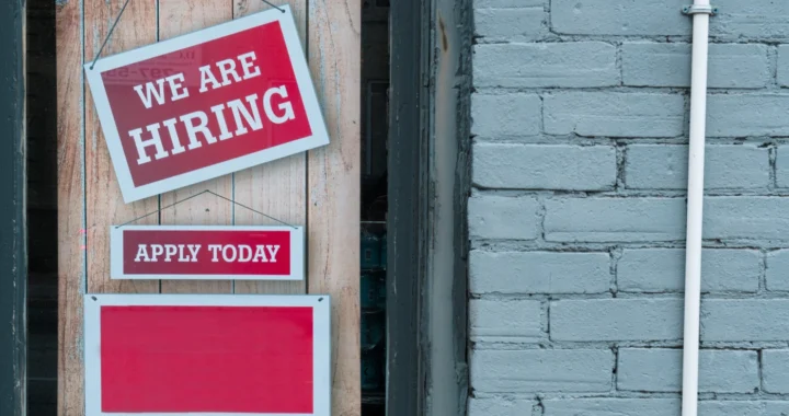 sebuah papan pengumuman bertuliskan ‘we are hiring’ tergantu di depan pintu