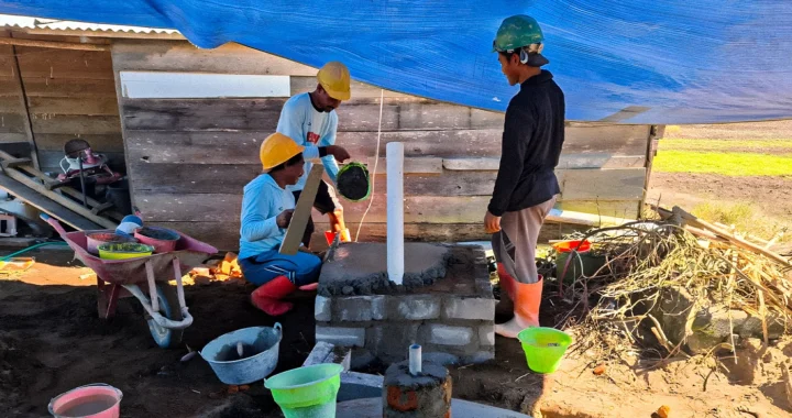 tiga pria sedang membangun fasilitas biogas