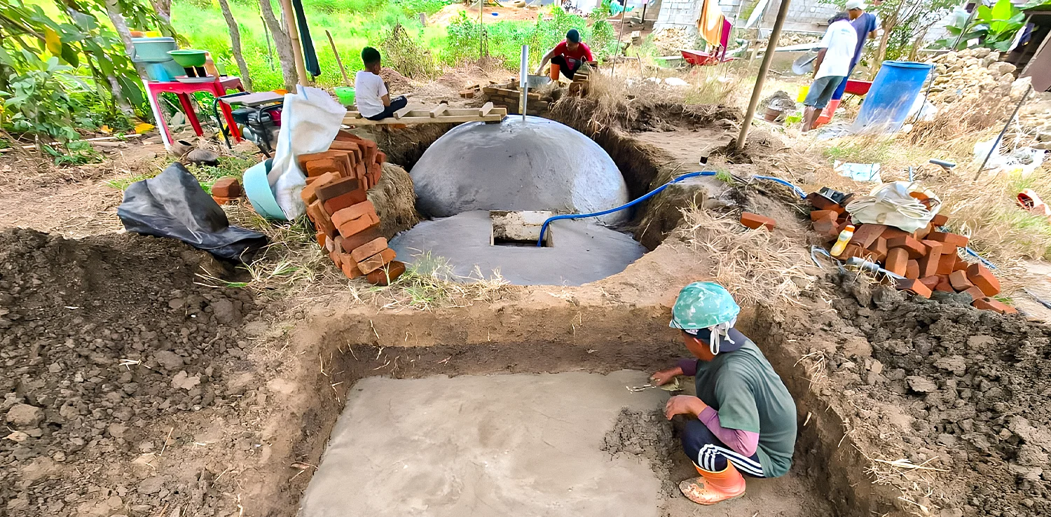 seorang pria sedang membangun fasilitas biogas