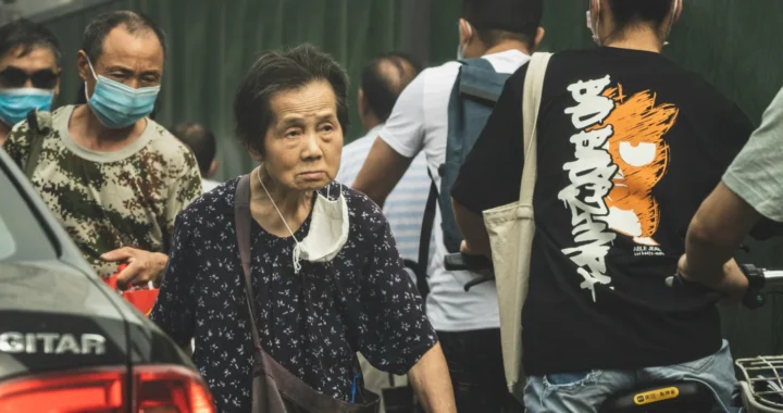 seorang nenek berbaju hitam berjalan di antara orang-orang