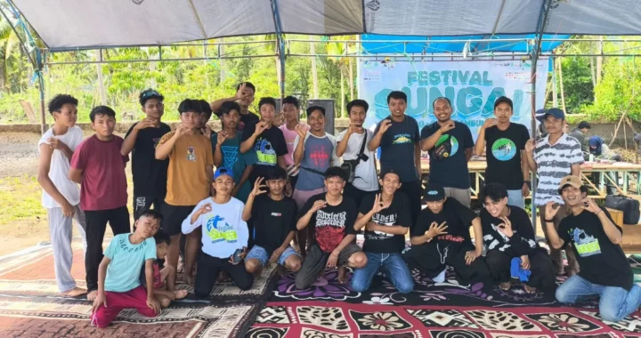 sekelompok orang berfoto bersama dengan sebagian berdiri dan sebagian berjongkok.