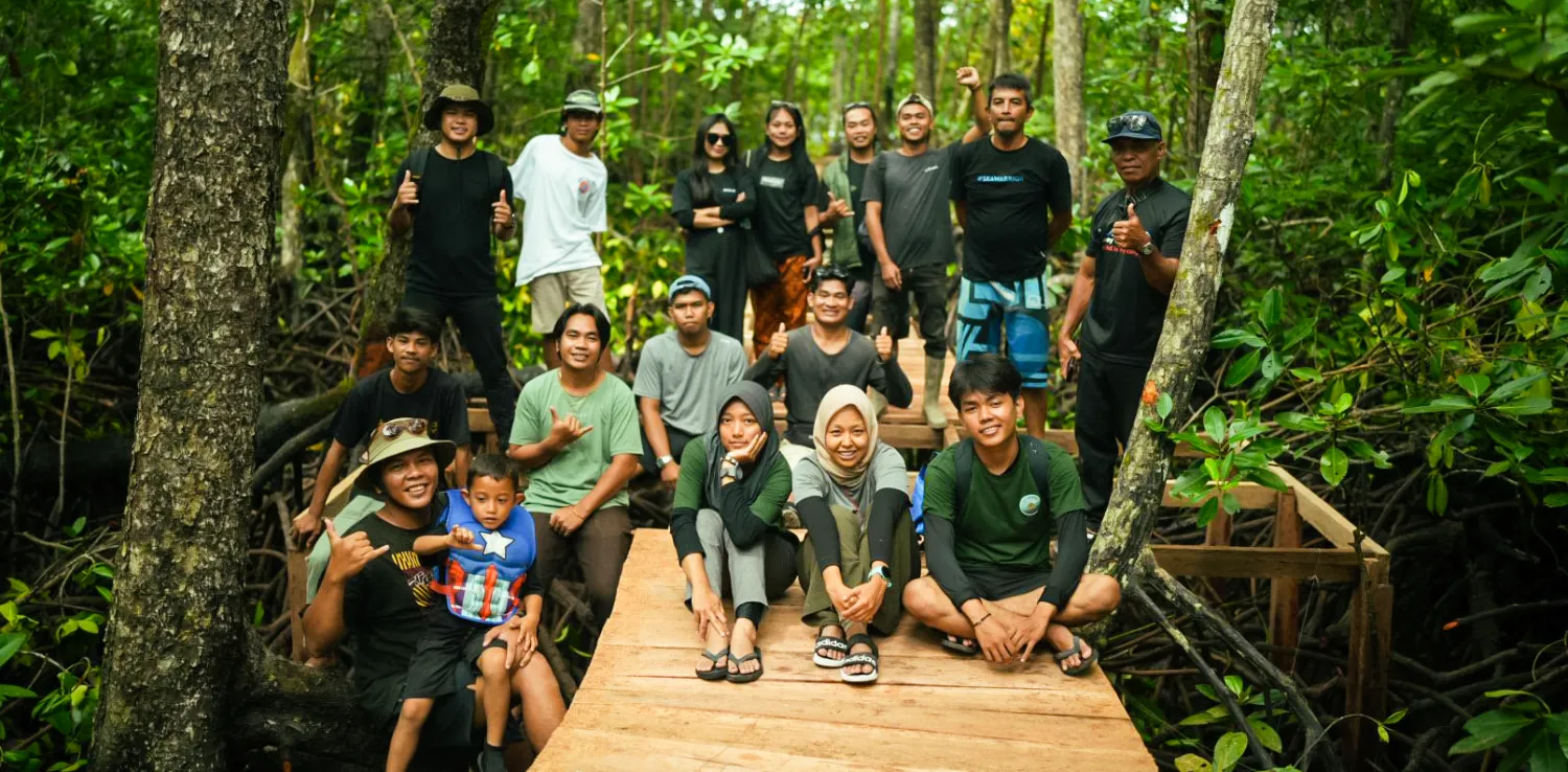 orang berfoto bersama di tengah hutan