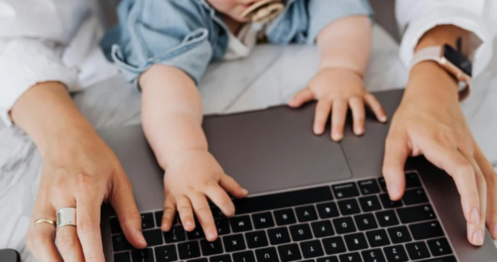 tangan ibu dan bayi di atas keyboard laptop