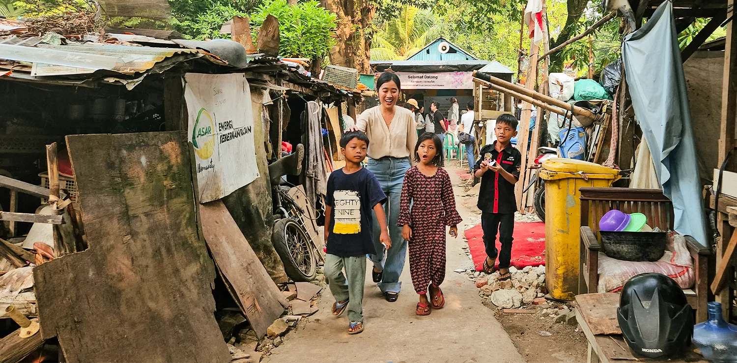 seorang perempuan berjalan dengan tiga anak di gang sempit