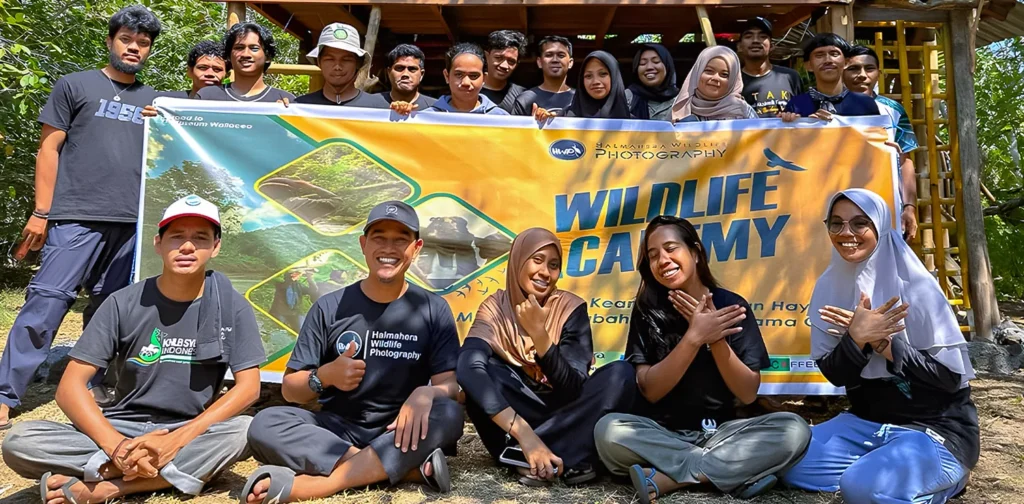 sekelompok orang berfoto bersama dengan latar spanduk ‘wildlife academy’.