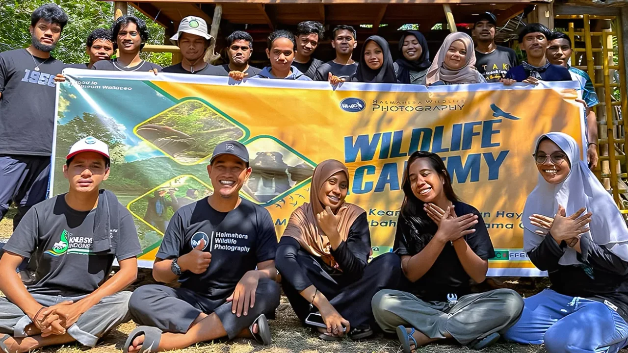 sekelompok orang berfoto bersama dengan latar spanduk ‘wildlife academy’.