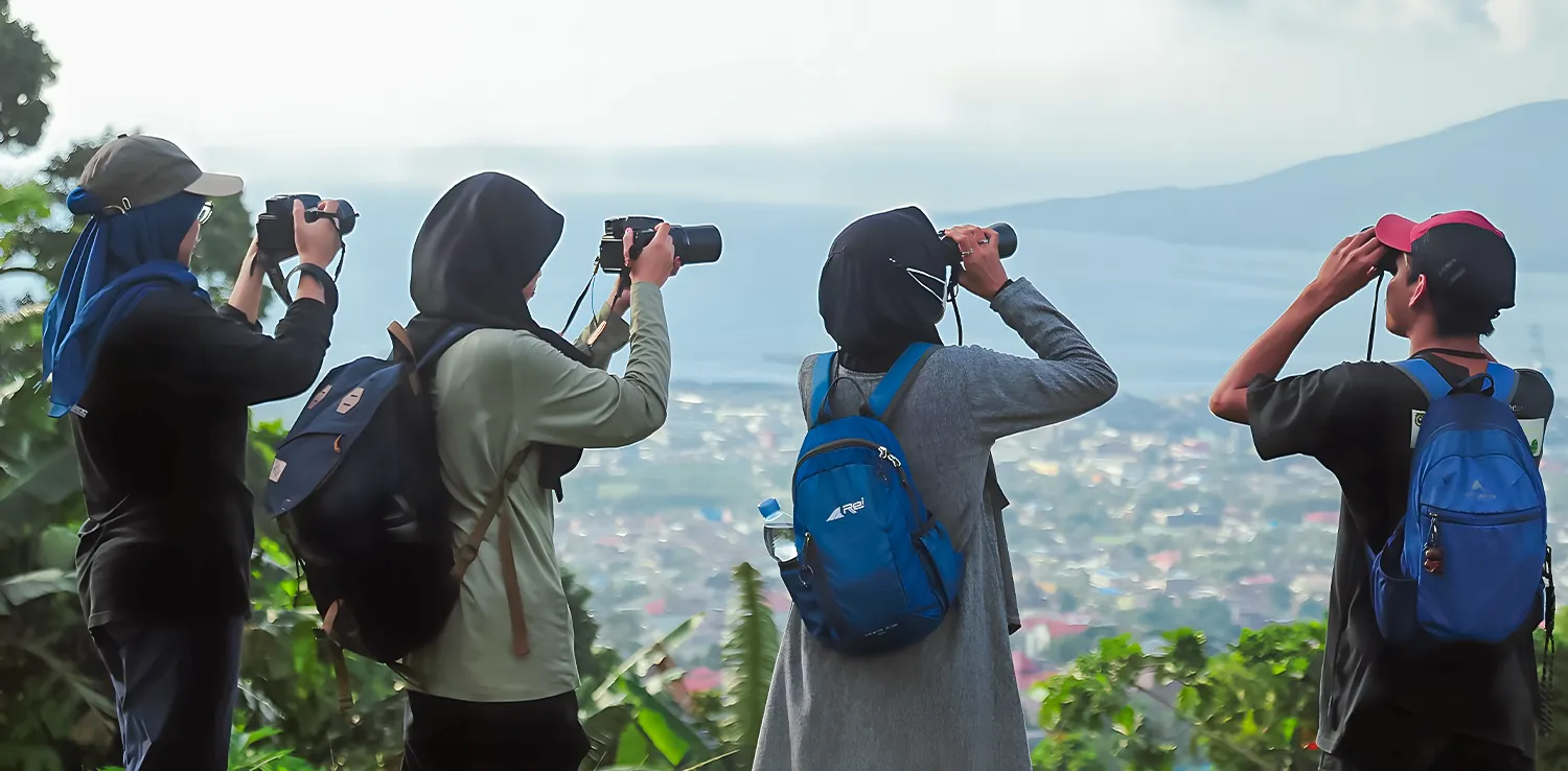 empat orang sedang meneropong dan memotret.