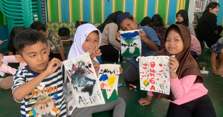 Empat anak dalam acara literasi Inisiasi Lantara berpose di depan kamera sambil menunjukkan pouch buku hasil lukisan mereka sendiri.