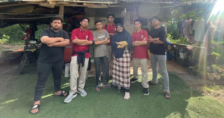 Sekelompok laki-laki muda berfoto bersama seorang ibu di depan sebuah rumah.