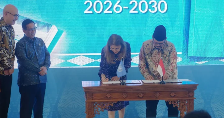 dua orang sedang menandatangani dokumen di atas meja