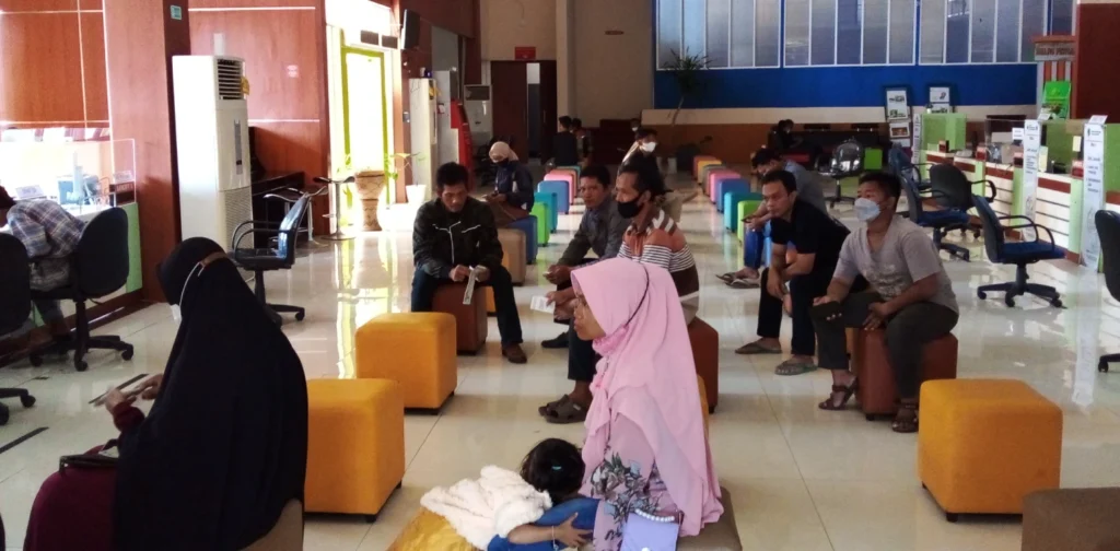 kantor pelayanan publik dengan beberapa pengunjung yang mengantri di tempat duduk.