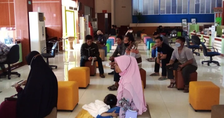 kantor pelayanan publik dengan beberapa pengunjung yang mengantri di tempat duduk.