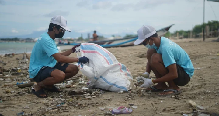 dua pria mengumpulkan sampah di pantai