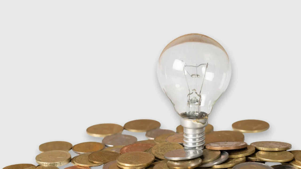 Sebuah bohlam di atas tumpukan koin.