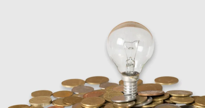 Sebuah bohlam di atas tumpukan koin.