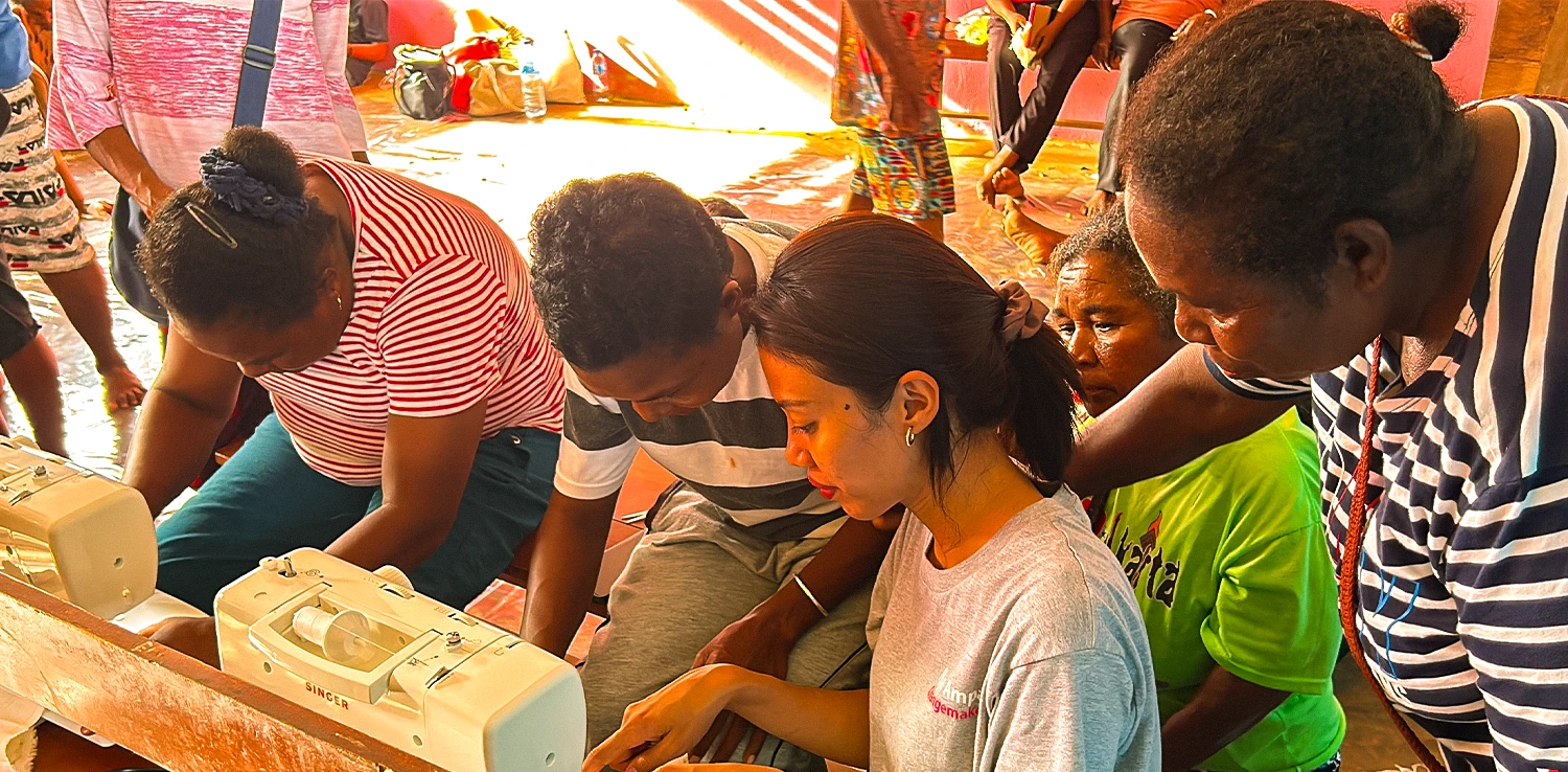 lima perempuan duduk di depan mesin jahit
