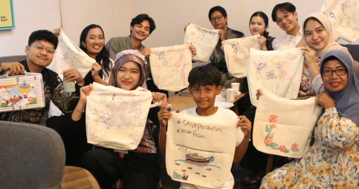 sepuluh orang muda berpose menghadap kamera sambil membawa tote bag yang telah dihias