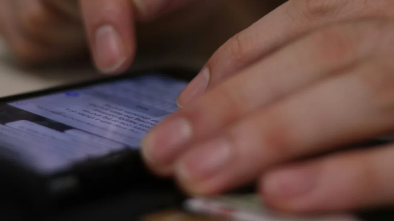 sepasang tangan sedang mengetik di layar ponsel