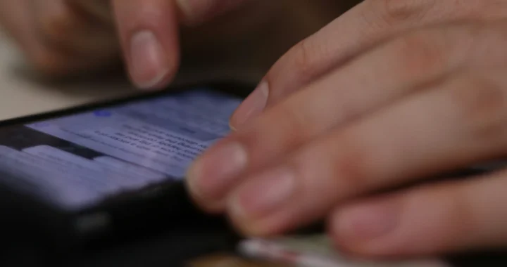 sepasang tangan sedang mengetik di layar ponsel