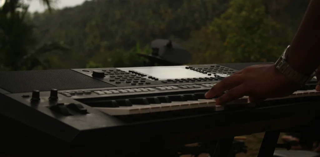 tangan memainkan keyboard di hadapan hutan