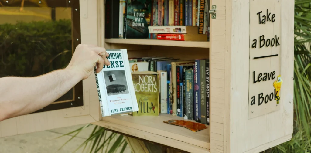 Seseorang sedang mengambil sebuah buku dari rak kecil