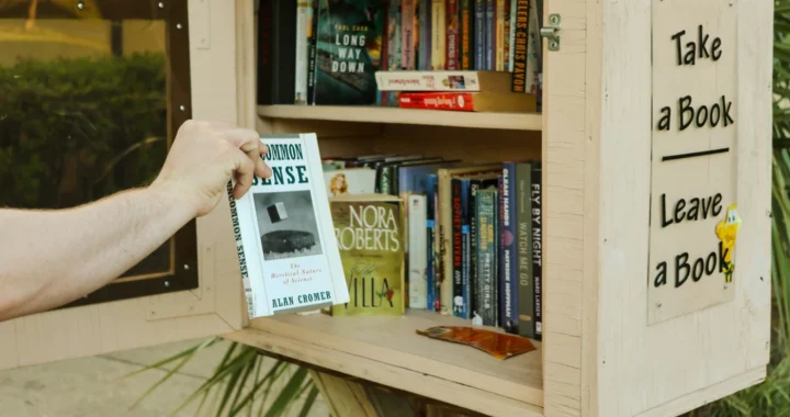 Seseorang sedang mengambil sebuah buku dari rak kecil