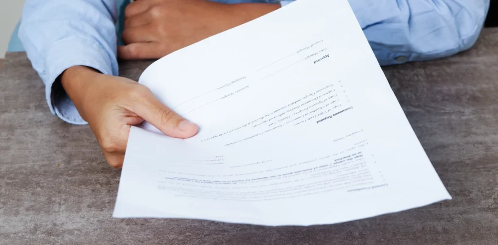 seseorang berkemeja biru menyerahkan kertas