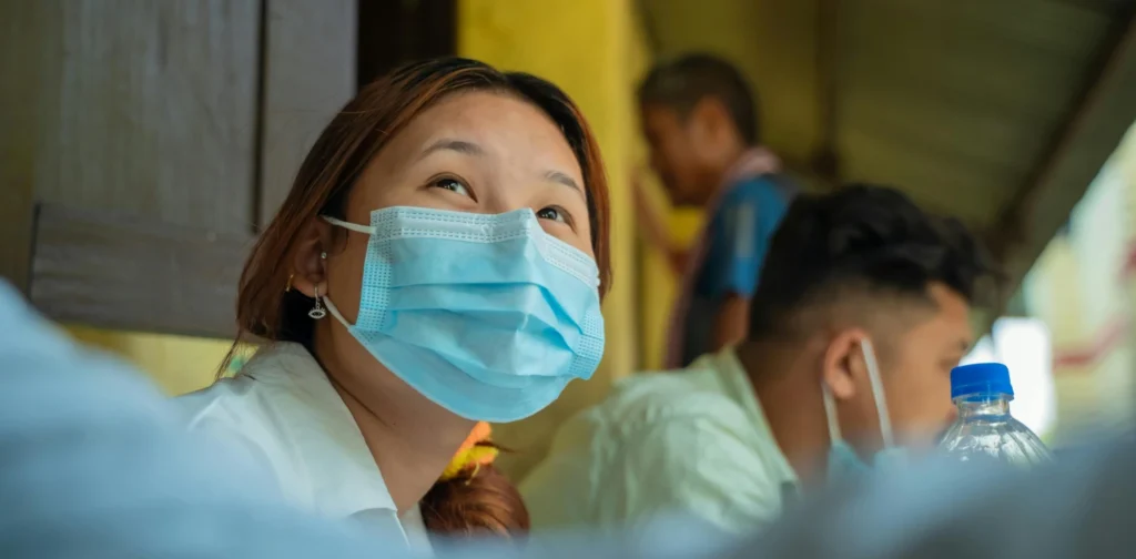 seorang perempuan asia mengenakan masker biru muda