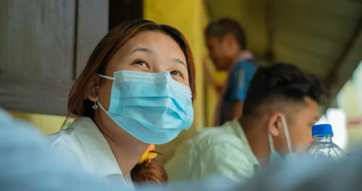 seorang perempuan asia mengenakan masker biru muda