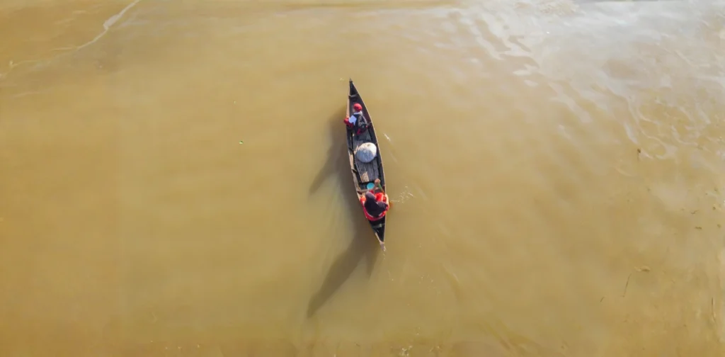 foto udara seorang ibu dan anak di atas perahu menyusuri perairan