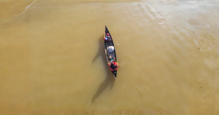 foto udara seorang ibu dan anak di atas perahu menyusuri perairan