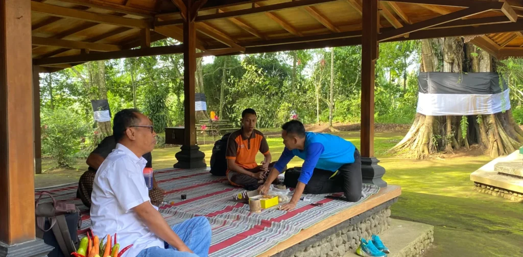 empat orang duduk lesehan di halaman sebuah bangunan