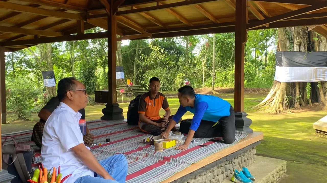 empat orang duduk lesehan di halaman sebuah bangunan
