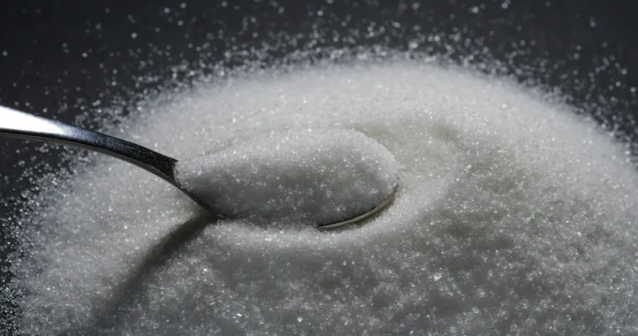 sendok kecil di tengah tumpukan gula pasir